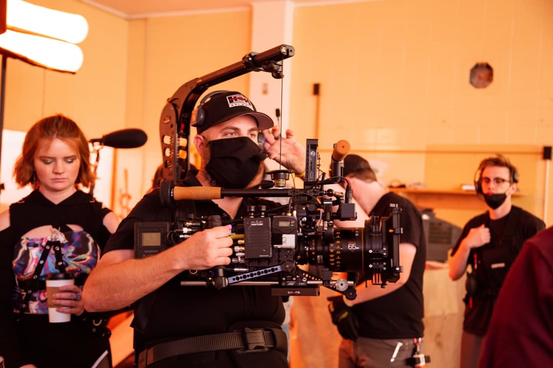 Behind the scenes photo 68 from Clone Cops production showing cinematographer corey allen prepares for a shot with an easyrig